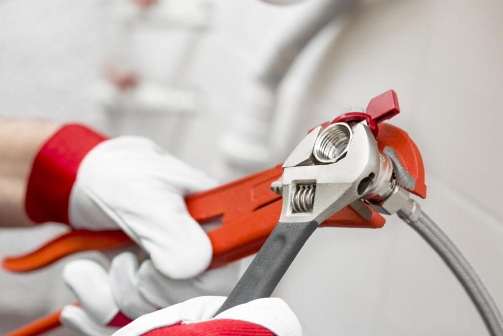 Plumber holding pipe wrenches for an emergency repair in Suwanee