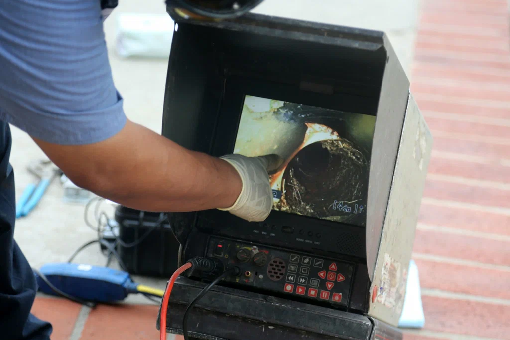 Technician viewing a drain inspection camera in Suwanee